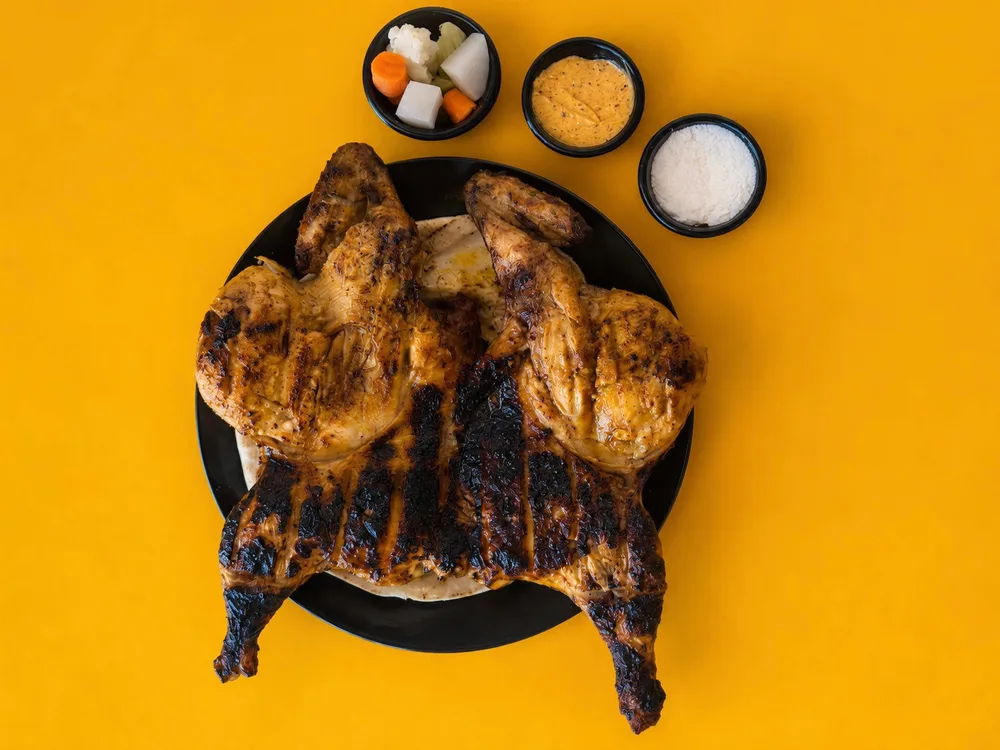 Frango Grelhado servido num prato com acompanhamentos